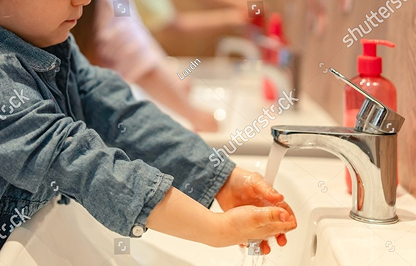 Child washing hands at a sink